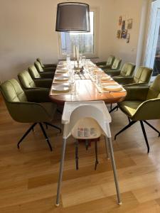a dining room with a long table and green chairs at Penthouse perfekt für Teams, Familien und Gruppen in Bad Mergentheim