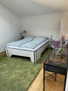 a bedroom with a bed and a glass table at Penthouse perfekt für Teams, Familien und Gruppen in Bad Mergentheim