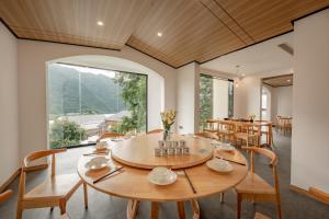 a dining room with a table and chairs and a large window at Healing House--Free one way pick up service over 2 nights in Zhangjiajie