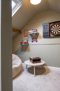 Zimmer mit einem Tisch und einer Dartscheibe an der Wand in der Unterkunft Rowan Cottage Lanchester-Escape Beyond Holiday Lets in Lanchester