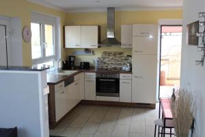 a kitchen with white cabinets and a stove top oven at feWo-zum Blauenblick in Buggingen