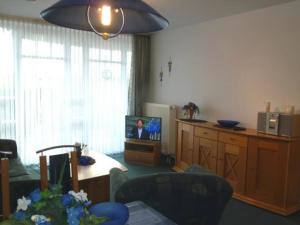 a living room with a television and a table with chairs at de ebb in Dorum-Neufeld