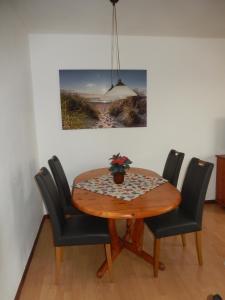 a dining room table with chairs and a potted plant on it at Landhaus Katharina in Westerdeichstrich