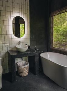 a bathroom with a tub and a sink and a mirror at DeerWood villa in Hinkong