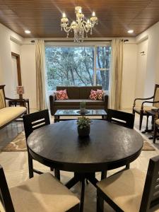a living room with a table and a couch at Zephyr 2BHK Lakeview Near Mall Road & Naini Lake in Nainital