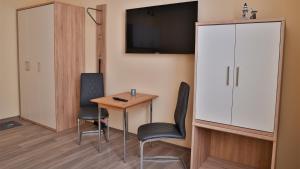 a room with a table and chairs and a tv at Wohnung "Wolgast" in Gützkow