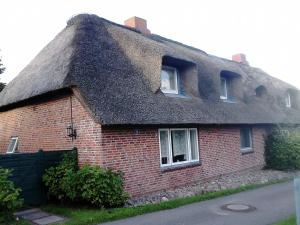 a thatched house with a thatched roof at Friesenhaus am Meer in Dagebüll