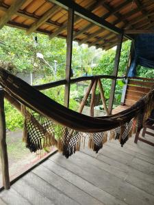 a hammock on a wooden deck in a house at Casa Anahata in Algodoal