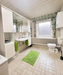 a bathroom with a toilet and a sink and a window at Ferienwohnung Meyer in Surwold +16 photos