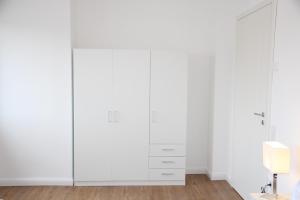 a bedroom with white wardrobes at Casa Kronengarten Nr 7 in Hilden