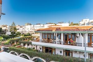 a building with people sitting on a balcony at MalagaSuite El Levante Apartments in Torremolinos