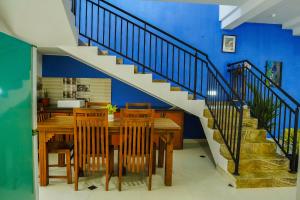 a dining room with a wooden table and a staircase at Rosemary Villa - Welegoda, Matara in Matara