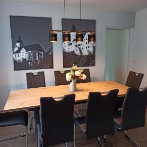 a dining room table with chairs and a vase with flowers at Ferienwohnung zur alten Zeche in Johanngeorgenstadt