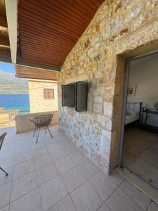 a stone building with a patio with a table and a chair at Sofia Limeni in Limeni