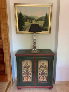 a lamp on top of a cabinet in front of a painting at Luxuriöses Ferienhaus in Luftkurort Lückendorf