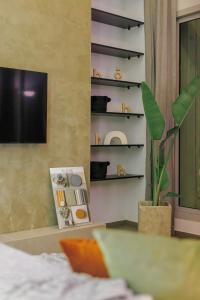sala de estar con TV y planta en Beyti, en Rabat