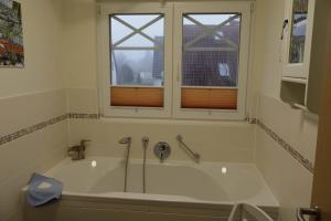 a bath tub in a bathroom with a window at Boddenblick 3B in Fuhlendorf