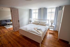 a bedroom with a white bed and a living room at Apartment No5 in Stralsund
