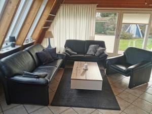 a living room with two leather couches and a coffee table at Ferienhaus LiLeBe in Damp +9 photos