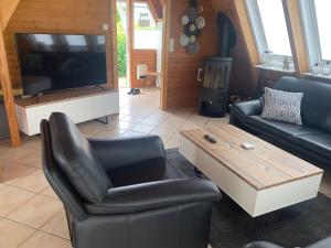 a living room with a couch and a table and a tv at Ferienhaus LiLeBe in Damp
