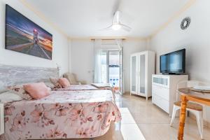 a bedroom with a bed and a flat screen tv at MalagaSuite El Levante Apartments in Torremolinos