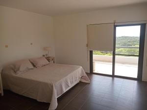 a bedroom with a bed and a large window at Tranquila Casa de Campo in La Granja