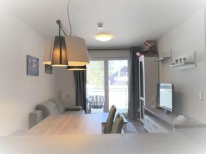 eine Küche und ein Esszimmer mit einem Tisch und einem TV in der Unterkunft Blackforest Lounge direkt an der Skipiste, inkl Parkplatz und Skiraum in Rinken