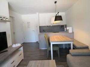 ein Wohnzimmer mit Tisch und Küche in der Unterkunft Blackforest Lounge direkt an der Skipiste, inkl Parkplatz und Skiraum in Rinken