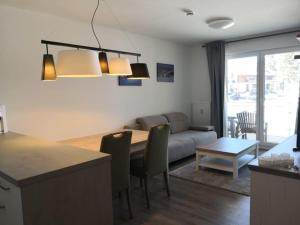 eine Küche und ein Wohnzimmer mit einem Tisch und einer Couch in der Unterkunft Blackforest Lounge direkt an der Skipiste, inkl Parkplatz und Skiraum in Rinken