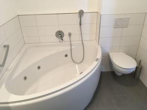 eine weiße Badewanne im Bad mit WC in der Unterkunft Blackforest Lounge direkt an der Skipiste, inkl Parkplatz und Skiraum in Rinken