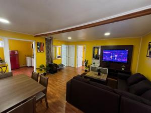 a living room with a couch and a tv at Casa Grande en Osorno central en parcela 2 para 6 p in Osorno