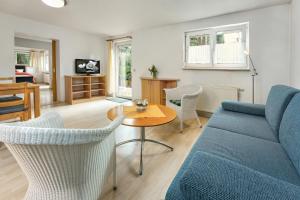 un salon avec un canapé bleu et une table dans l'établissement Thermen Appartements Gabriela, Appartement 60 qm, EG, à Bad Krozingen
