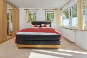 une chambre avec un grand lit avec des oreillers rouges dans l'établissement Thermen Appartements Gabriela, Appartement 60 qm, EG, à Bad Krozingen