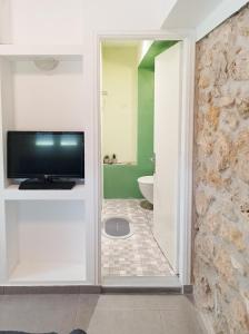 a bathroom with a television and a bathroom with a tub at Marina's Garden Nests - Holiday Bliss Getaways in Romanós +34 photos