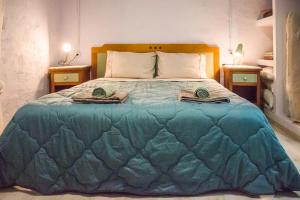 a bedroom with a large blue bed with two tables at Marina's Garden Nests - Holiday Bliss Getaways in Romanu