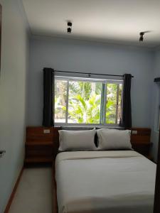 une chambre avec un lit et une fenêtre dans l'établissement The Leaf Cosy Cottage, à Ban Krut