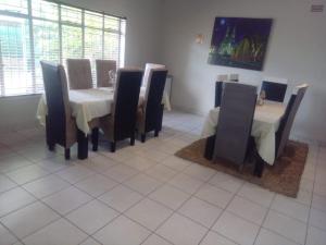 a dining room with chairs and a table and a table and chairsearcher at Simekhona Guest House in Aangewysd