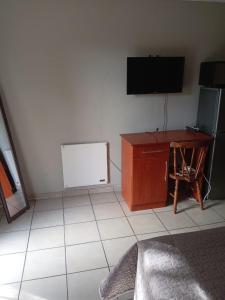 a room with a tv and a desk and a table at Simekhona Guest House in Aangewysd