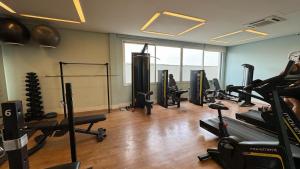 a gym with several treadmills and machines in a room at Flat Wise Confort in São Paulo