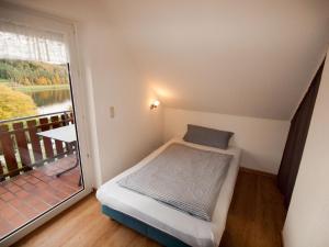 a small bed in a room with a balcony at Komfortable Ferienwohnung Mit Seeblick in Bad Arolsen +26 photos