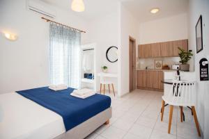 a bedroom with a bed and a small kitchen at Seaside Suites in Kavos