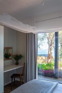 a bedroom with a bed and a large window at Loerie's Perch - On Knysna Lagoon in Knysna