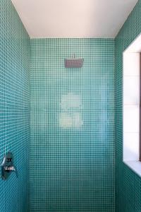 a green tiled bathroom with a shower at Loerie's Perch - On Knysna Lagoon in Knysna