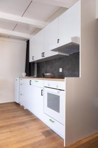 a kitchen with white cabinets and a counter top at La Garçonnière in Colombier +10 photos