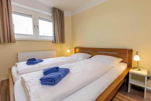 - une chambre avec 2 lits et des serviettes bleues dans l'établissement ancora Marina Haus 1 Nr 02, Typ 2, à Neustadt in Holstein 17 autres photos