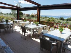 un grupo de mesas y sillas en un patio en Agriturismo Il Giardino Degli Ulivi, en Lazise