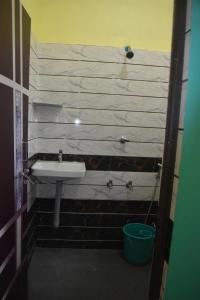 戈卡尔纳shivanugraha homestay的一间带水槽和水桶的浴室