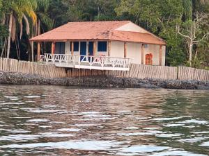 a house on the shore of a body of water at Pousada Trincheira in Ilha Comprida