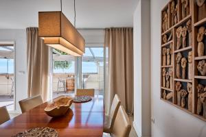 a dining room with a wooden table and chairs at Conquistador A - by Welcomely in El Campello