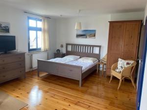 a bedroom with a bed and a dresser and a television at Studio 52 in Rankwitz